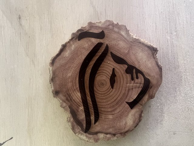 Stylized logo engraving on live-edge wood